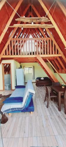 a attic room with a bed and a piano at Chalé Raio de Sol- Colônia Witmarsum in Palmeira