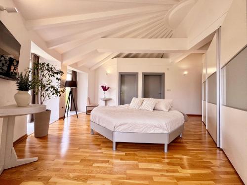 a bedroom with a white bed and a wooden floor at Royal Sun Villa in Sarajevo