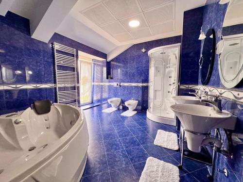 a blue bathroom with a tub and a sink at Royal Sun Villa in Sarajevo