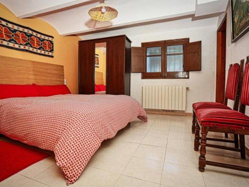 a bedroom with a bed and a chair in it at Can Micos - Masía de grupos 16 hasta 25 personas in Riudarenes