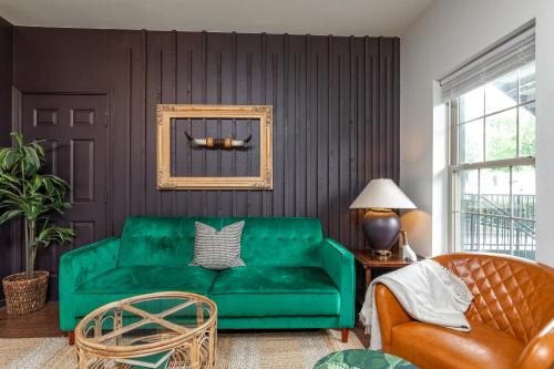 a living room with a green couch and a chair at Couples Condo Retreat Overlooking Golf Course in Branson West