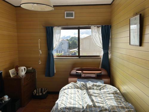 a bedroom with a bed and a window in it at 民宿とまとハウスTomato House in Funehiki