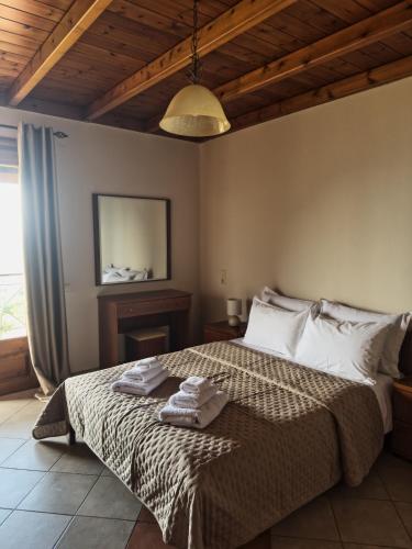 a bedroom with a bed with two towels on it at The Stone Alley in Konitsa