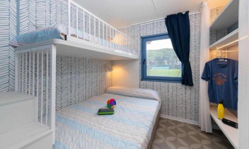 a small bedroom with a bunk bed and a ladder at Camping Pineta - Nikoli Tour in Cesenatico