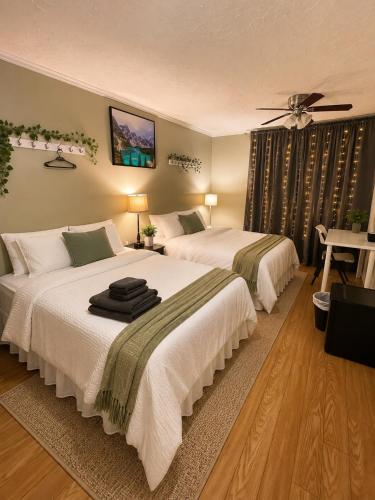 a bedroom with two beds and a ceiling fan at Glaive Home in Toronto