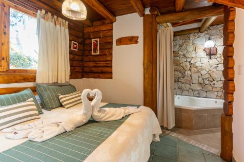 a bedroom with a bed with a towel animal on it at Cabañas Mapuche in Mar de las Pampas