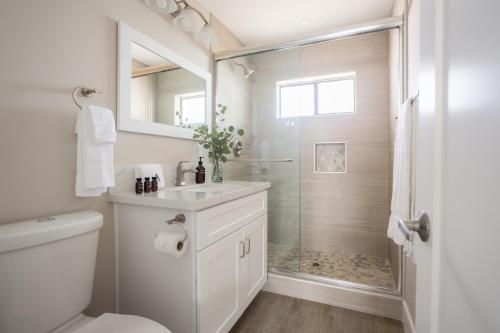 a white bathroom with a shower and a sink at Seashore Suites by AvantStay in San Diego