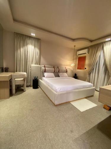 a bedroom with a large white bed and a desk at 4 Bedroom duplex in Orchid in Lekki