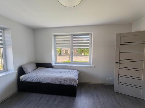 a bedroom with a bed and a window at Cozy Spark Studio Apartment in Kelmė