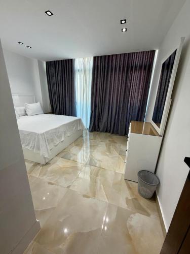 a bedroom with a bed and a marble floor at Retaj Waterfront Penthouse in Port Said