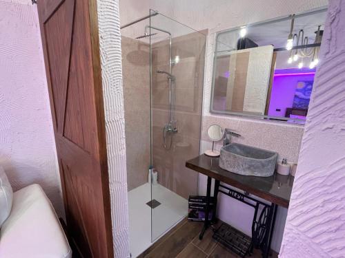 a bathroom with a glass shower and a sink at La Casa Los Patios in Mahora