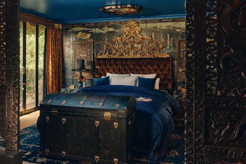 a bedroom with a king sized bed with a blue bedspread at Petit Ermitage in Los Angeles