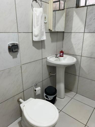 a small bathroom with a toilet and a sink at Casa no centro in Primavera do Leste
