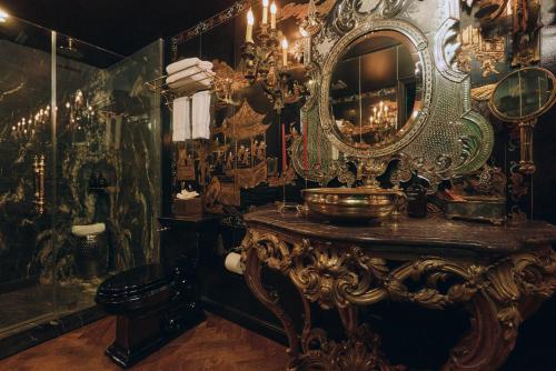 a bathroom with a mirror and a table with a sink at Petit Ermitage in Los Angeles