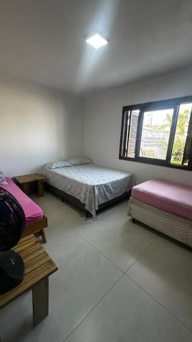 a room with two beds and a window at Canto dos pássaros in Tramandaí