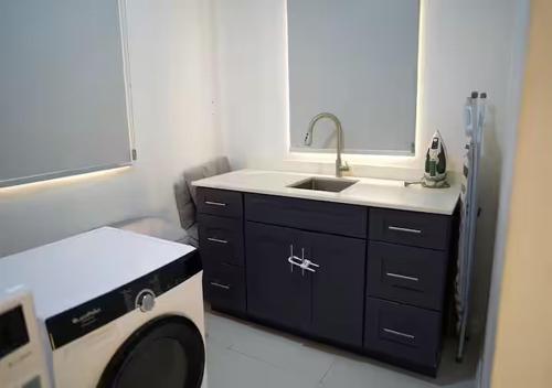 a kitchen with a sink and a washing machine at Onyx Villa in Ocho Rios