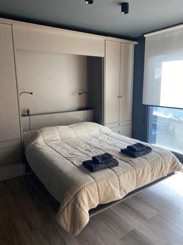 a bedroom with a bed with two towels on it at Edificio Pantera - monoambiente 18 in San Martín de los Andes