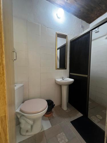 a bathroom with a toilet and a sink at peruibe pousada na areia in Peruíbe