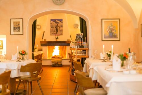 a dining room with tables and a fireplace at Der Erlhof Restaurant & Landhotel in Zell am See