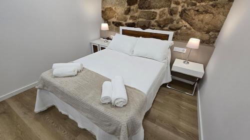 a bedroom with a large bed with towels on it at Mirada Sacra in Parada del Sil