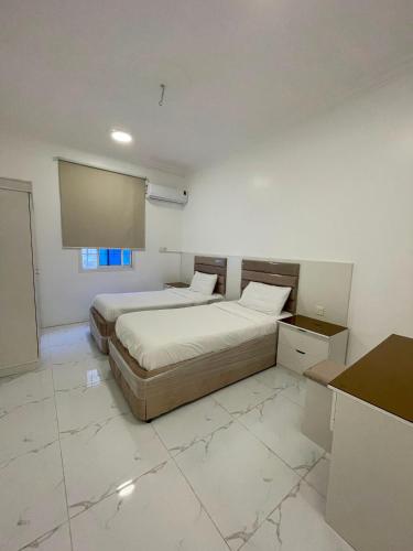 a bedroom with two beds and a projection screen at شقق سكنية مريحة in Tanomah