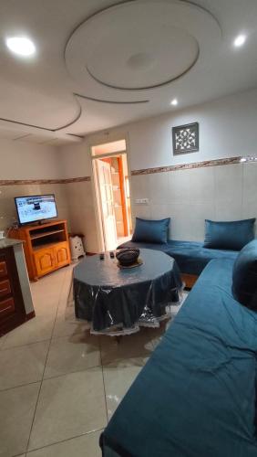 a living room with a blue couch and a table at Nekor Bay Appartement in Al Hoceïma