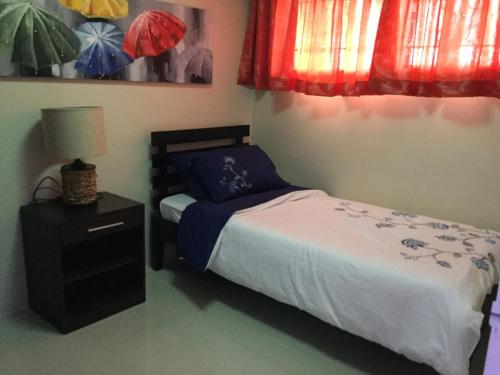 a small bedroom with a bed and a night stand at Bords Sweet Home in Davao City
