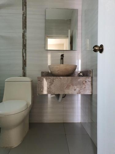a bathroom with a sink and a toilet at Casa de la Playa in Playa Azul