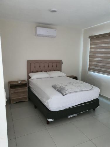 a bedroom with a bed and a window in it at Casa de la Playa in Playa Azul