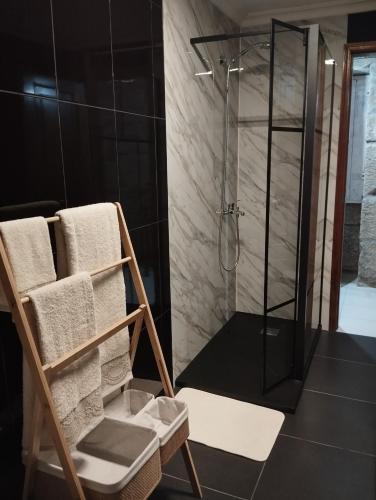 a bathroom with a shower and a wooden chair at Casa da Aldeia in Santa Cruz do Douro