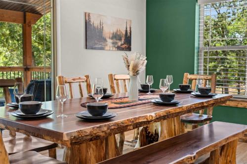 a wooden table with plates and glasses on top at LakeSides Retreat with Amenities in Hollister