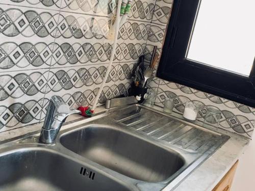 a stainless steel sink in a kitchen with a window at La vague in Île Pilau