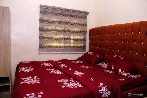 a bed with a red blanket and pillows on it at MF Supreme Hotels and suites in Ikorodu