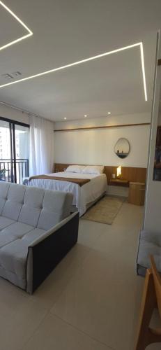 a large bedroom with a bed and a couch at Opus Gyro Vaca Brava Designer in Goiânia