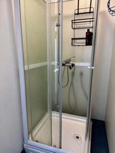 a shower with a glass door in a bathroom at Kammak Hostel Sisimiut in Sisimiut