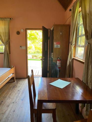 a dining room with a table and a bed and a window at The Village Inn in Placencia