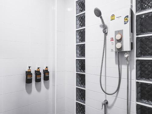 a bathroom with a shower with two bottles of soap at Na Sukhothai Hotel in Sukhothai