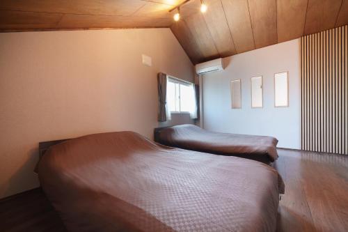 a bedroom with two beds in a room at plus81 OTARU Entire House 9min Walk from Minami Otaru Station in Otaru