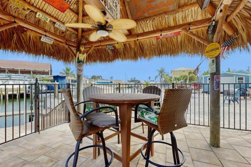 a table and chairs under a straw umbrella on a patio at Diversity in Saint James City