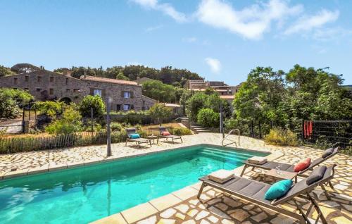 a swimming pool with lounge chairs and a house at Apaisante Villa Piscine in Taulis