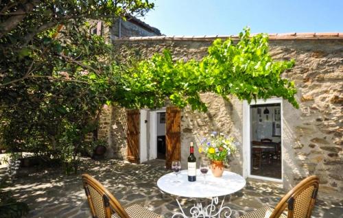a table with a bottle of wine on a patio at Apaisante Villa Piscine in Taulis