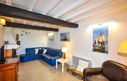 a living room with a blue couch and a table at Charmante Villa Piscine in Taulis