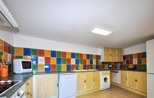 a kitchen with colorful tiles on the wall at Charmante Villa Piscine in Taulis