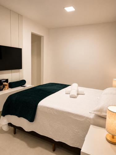 a bedroom with a large bed and a flat screen tv at Life Center in Caruaru