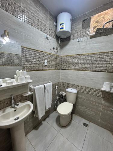 a bathroom with a toilet and a sink at Casa pyramids hotel in Cairo