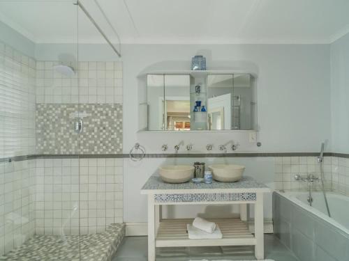 a bathroom with two sinks and a tub and a mirror at Inn-Style in Cape Town
