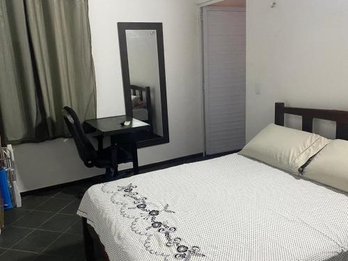 a bedroom with a bed and a desk with a mirror at Resort felicidade in Extremóz