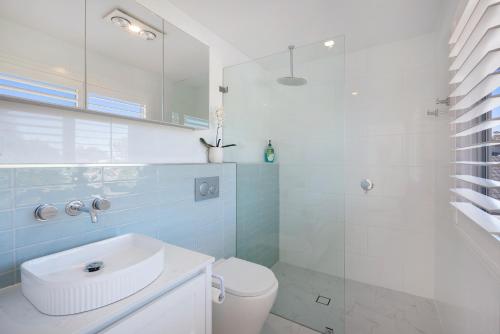 a bathroom with a toilet and a sink and a shower at The River Retreat in Sussex Inlet