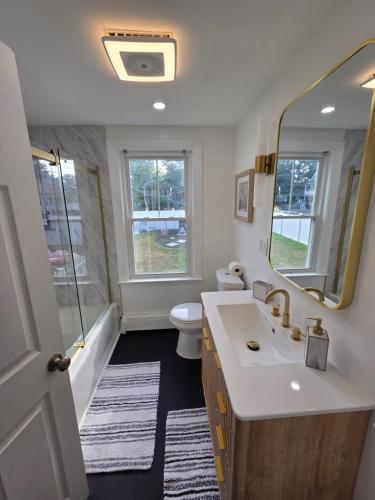 a bathroom with a sink and a toilet and a mirror at Sleeps 6 Near Boston, Providence & Gillette in Attleboro