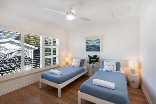a bedroom with two beds and a window at The River Retreat in Sussex Inlet
